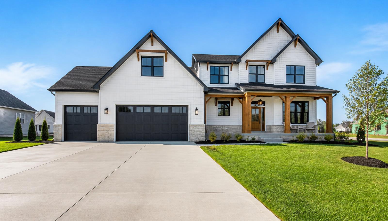 Modern white farmhouse with cedar accents and a sealed concrete driveway in Indiana